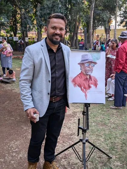 Posing with the finished portrait at the outdoor festival in Satara.