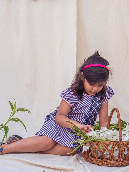 A quiet moment with a basket of flowers. This striped and patterned dress is a beautiful example of how mixed prints can create a unique and stylish look.