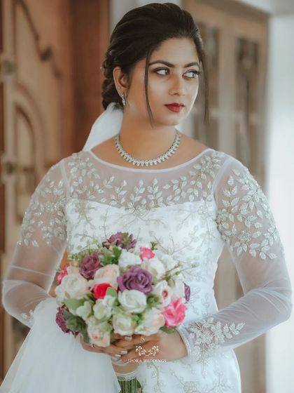 A beautiful portrait of the bride holding her colorful bouquet, her red lipstick adding a pop of color to her classic look.