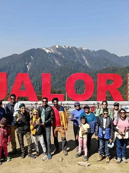Our happy group at the famous Jalori Pass sign during the Jibhi and Tirthan Valley trip. These trips are great for families and friends.