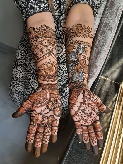 A detailed bridal mehendi in a fusion style, combining traditional motifs with modern Indo-Arabic patterns like bows and ribbons.