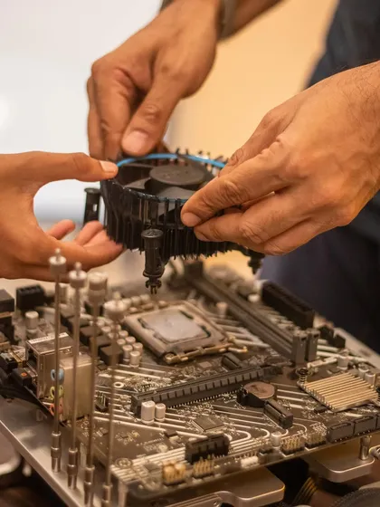 I guide a child's hands as we install the CPU cooler onto the motherboard. It's a delicate process, but with careful guidance, kids learn to handle complex components with confidence.