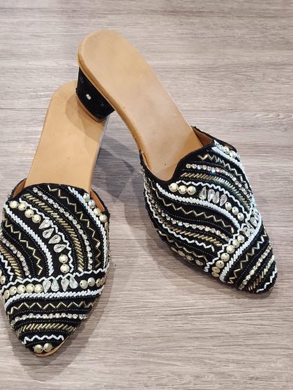 Another pair of my beautiful handcrafted mules. This black and white pair features intricate beadwork and shell details, adding a touch of boho-chic to your look.