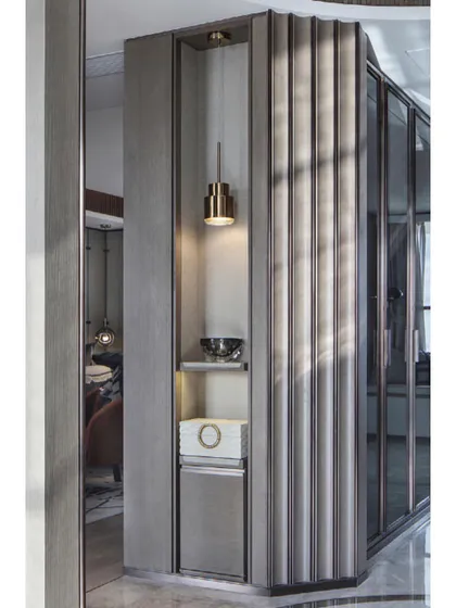 A close-up of our custom millwork, this fluted, upholstered corner unit includes a built-in niche with accent lighting. This detail demonstrates our commitment to creating functional yet beautiful bespoke storage solutions.