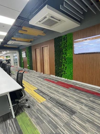 This long corridor in a busy office is broken up by panels of preserved moss set against wood-paneled walls. This design adds visual interest and a touch of nature, improving the experience of walking through what would otherwise be a purely functional space.