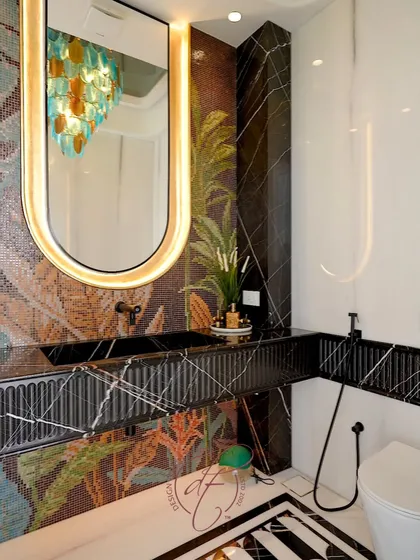 A full view of the powder room, showcasing the bold interplay of black and white flooring, black marble, and the colorful mosaic wall. It's a space designed to surprise and delight guests.