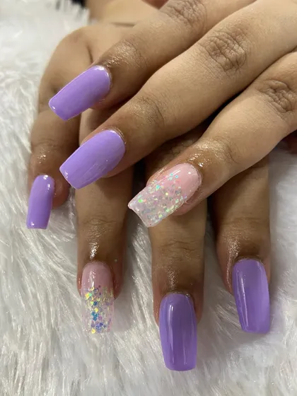 A beautiful set of long square nails in a soft lavender color, with sparkling glitter accent nails. A simple yet stunning look.