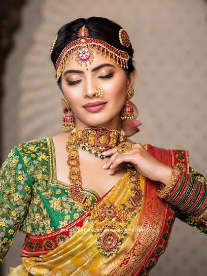 A complete South Indian bridal look, featuring a flawless, glowing base and soft glam eye makeup that complements the traditional gold jewelry and vibrant silk saree. This is a perfect example of the radiant and long-lasting bridal makeup I love to create.