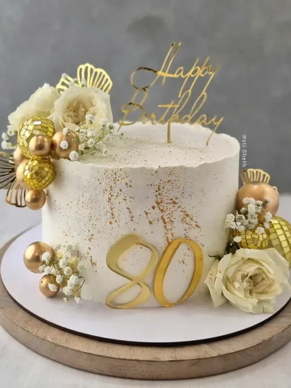An elegant and timeless cake for an 80th birthday celebration. This 2kg Pineapple cake is decorated in classic beige and gold with fresh florals.