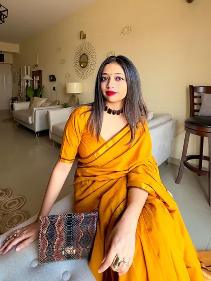 The full look with the yellow khadi saree and a snakeskin print bag. The mix of textures and earthy tones creates a very chic and put-together festive look.