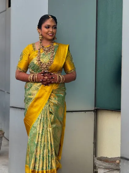 A full-length shot of Prithivi, showcasing her entire bridal ensemble. The makeup, hair, and saree come together to create a cohesive and stunning traditional look.