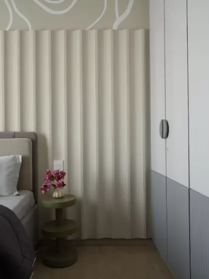A serene and stylish kids' bedroom designed with a perfect blend of elegance and comfort. The vertical fluted wall panels create a sense of height and texture, while the abstract swirl design above adds a playful yet sophisticated touch.