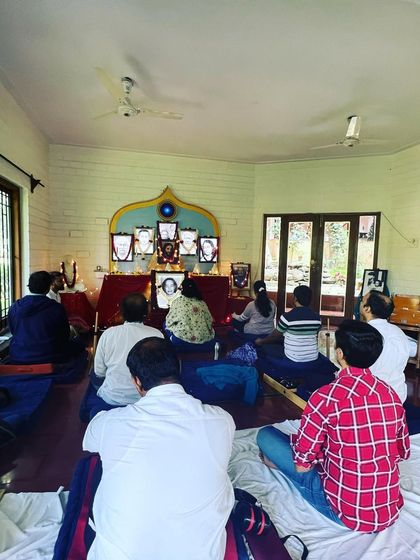 A group of devotees meditating together. The practice of sitting in stillness with others helps to reinforce our own efforts and deepens our experience of inner peace.