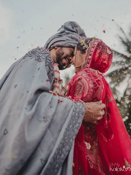 An intimate, low-angle shot of the couple embracing under a shower of petals. This perspective creates a powerful and emotional image.