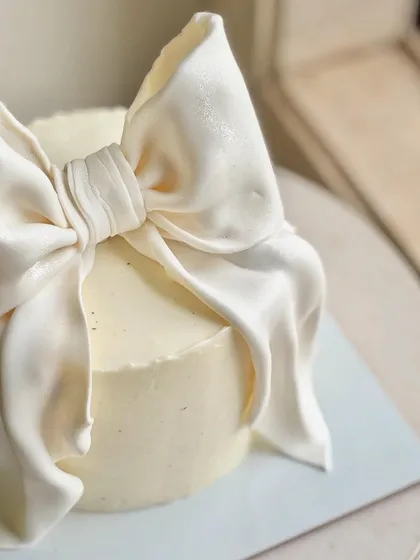 A detailed close-up of the incredible fondant bow, showing the realistic fabric-like folds and texture. It’s pure edible artistry.