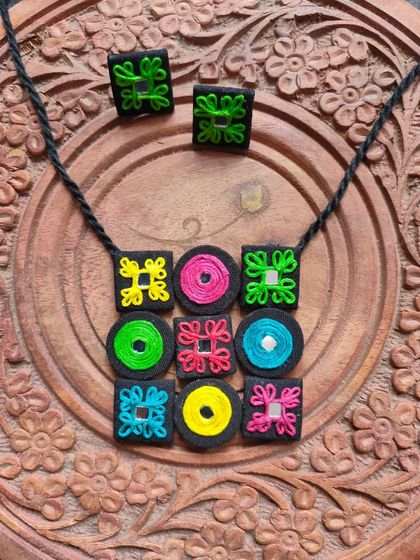 A customized necklace set I made for a client, featuring a colorful grid of embroidered fabric patches with mirror work. This is a great example of how we can create a unique piece based on your ideas.