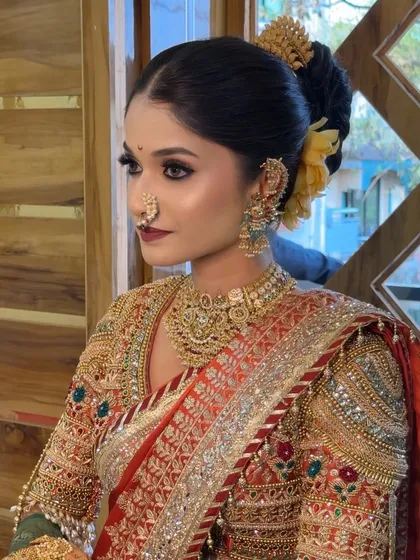 A close-up of a stunning Maharashtrian bride, highlighting the detailed makeup, traditional nath, and elaborate gold jewellery.