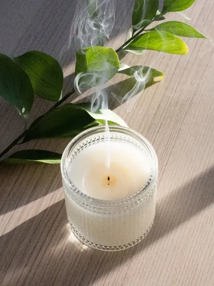My candles are made to be enjoyed from start to finish. Here, a recently extinguished soy wax candle in a textured glass jar sends up a gentle wisp of smoke, showing the clean burn you can expect from my handmade products.