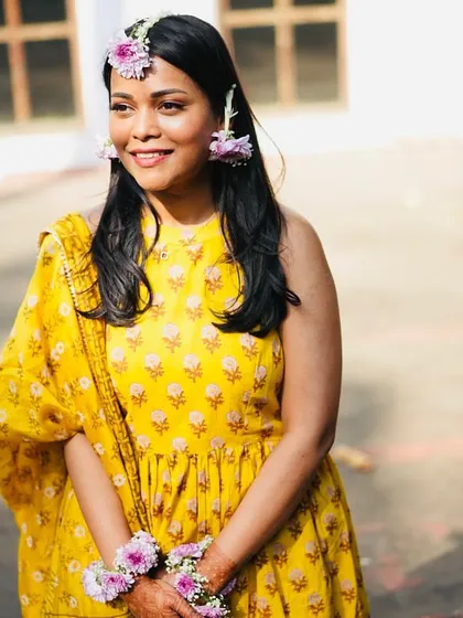 The bride's floral jewellery was custom-made to complement her yellow Haldi outfit. I chose delicate purple flowers to add a pop of contrasting color, creating a fresh and modern look for her pre-wedding celebration.