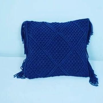 The front of our deep blue macrame cushion cover, featuring a classic diamond knot pattern. It's a simple way to add a pop of color and texture.