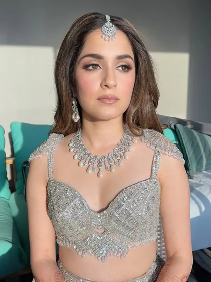 Sun, sparkle, and shine. This bride is glowing in the sunlight, her silver-grey lehenga and diamond jewelry perfectly complemented by a luminous makeup look with a sharp, defined eye.