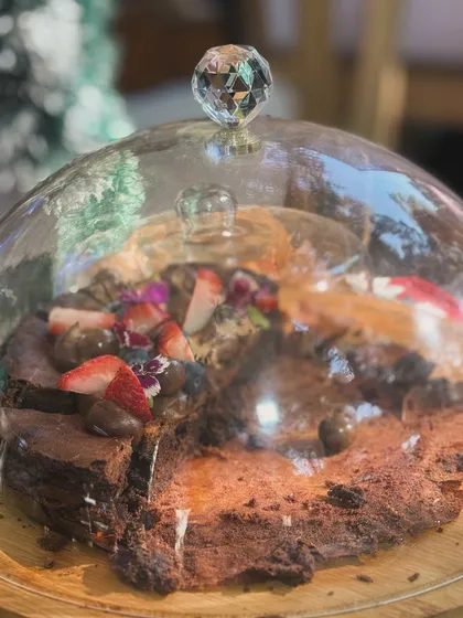 A flourless chocolate cake under a glass cloche at a pop-up event. It’s always a pleasure to connect with people and share my products in person.