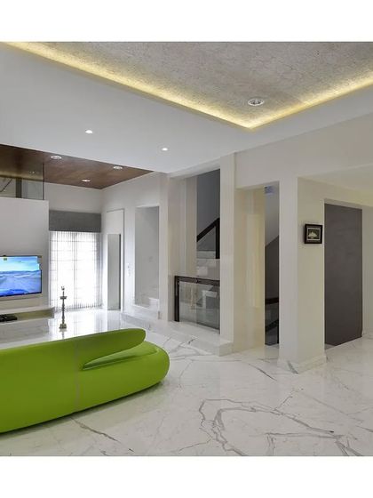 An all-white living room is given a playful and modern twist with a single, vibrant green sofa. This pop of color acts as a focal point, proving that minimalism can be both serene and fun.