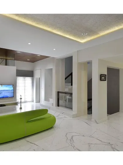 An all-white living room is given a playful and modern twist with a single, vibrant green sofa. This pop of color acts as a focal point, proving that minimalism can be both serene and fun.