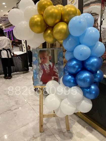 A personalized welcome easel is a lovely way to greet guests. Here, I framed a photo of the baby with a cascade of blue, white, and gold balloons.