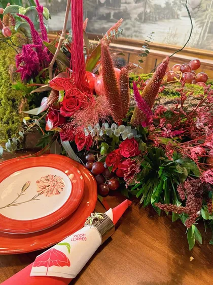 A close-up on a section of the floral runner, showcasing the variety of red flowers and textures used in the design.