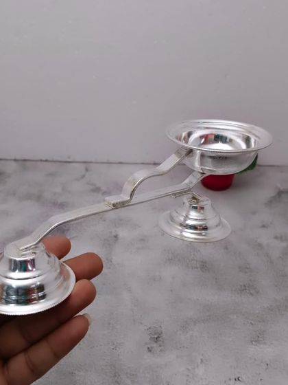 A German silver harathi stand, used for waving camphor light before the deity.