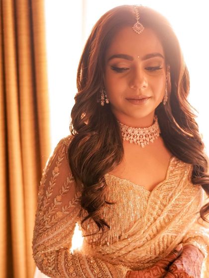 Another artistic shot in the warm light, highlighting the shimmering eyeshadow and radiant skin.