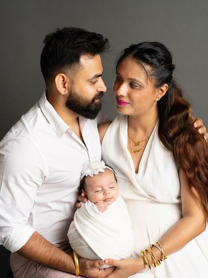 A classic family portrait showcasing the loving gaze between parents and their precious newborn. These are the moments that truly define the beginning of your new life together.
