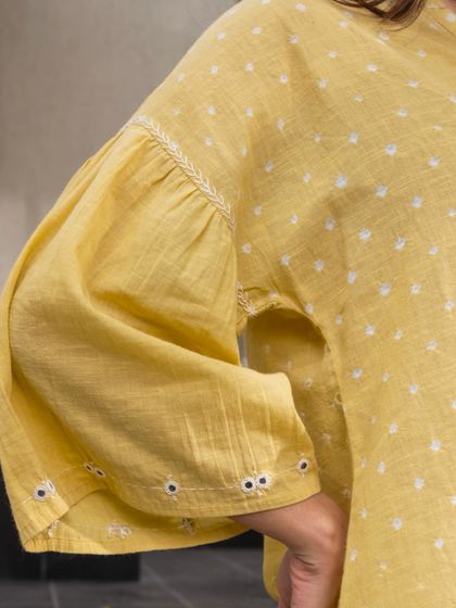 The gathered bishop sleeves on this yellow Suhani Bandhani top add a touch of volume and romantic flair. The cuffs are detailed with hand embroidery, highlighting our commitment to small, beautiful details.