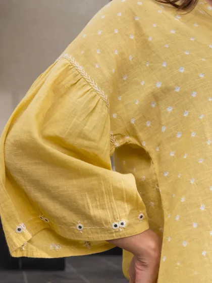 The gathered bishop sleeves on this yellow Suhani Bandhani top add a touch of volume and romantic flair. The cuffs are detailed with hand embroidery, highlighting our commitment to small, beautiful details.