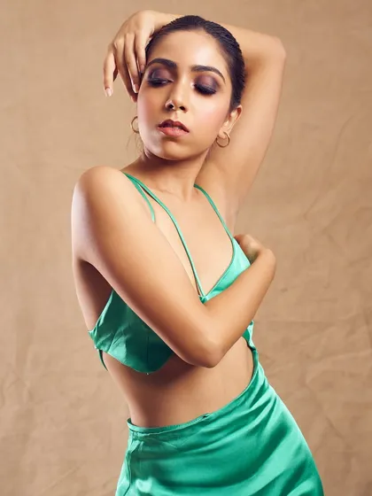 This pose showcases the beautiful drape of the dress and the dramatic eye makeup, creating a look that is both soft and powerful.