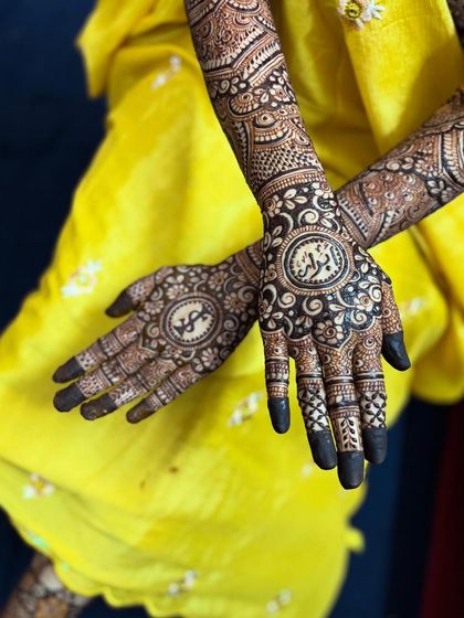 A close-up of the back of the hands, featuring the initial 'S' and the name 'Abrar' in beautiful circular frames.