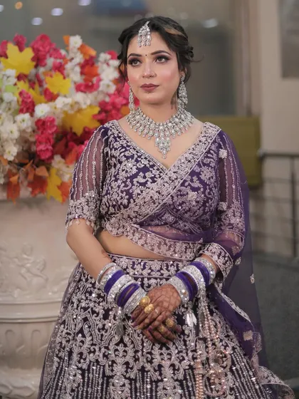 A close-up of the intricate silver embroidery and the perfectly matched makeup. The look is regal and sophisticated.