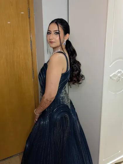 A full side view showing the complete look. The structured gown, the flowing ponytail, and the confident pose all come together for a stunning cocktail night appearance.
