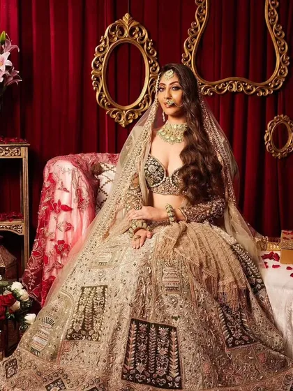 This modern bridal look features soft, romantic waves and a stunning lehenga. The makeup is glamorous yet understated, allowing the bride's natural beauty and the intricate outfit to take center stage.