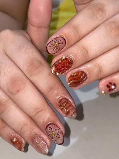 An autumn-inspired set with warm brown tones, glitter, and delicate gold floral and swirl patterns. This shows how to create beautiful seasonal designs.