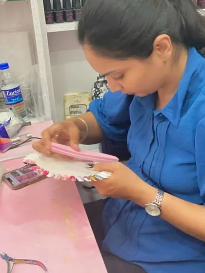 A student works on her filing technique, an essential skill for creating well-shaped and balanced nails.