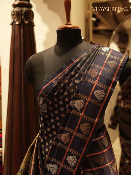 A unique Kanjivaram in deep navy blue, featuring a combination of checks and polka dots with silver and copper zari buttas.