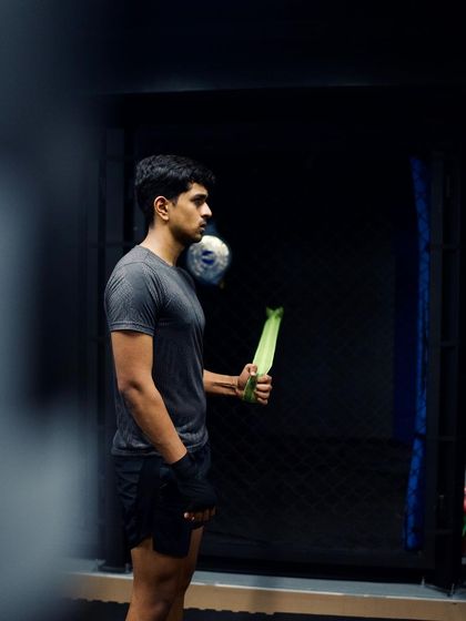 A fighter stands ready, holding a pad, prepared for the next drill.