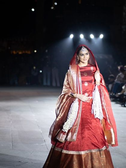 A front-facing shot of Kriti Sanon on the ramp, capturing her confident walk and the elegance of the Banarasi silk outfit.