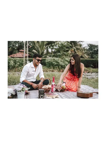 A picnic-themed pre-wedding shoot in a lovely green field. This shot captures the relaxed and happy atmosphere of a couple sharing a special day outdoors.