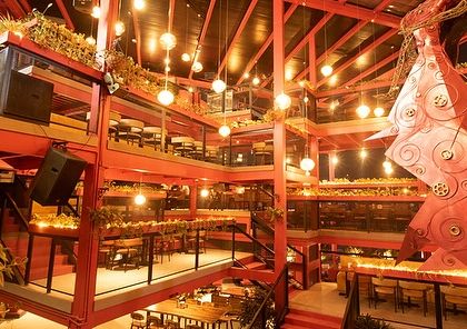 The multi-story atrium of Big Pitcher, where lighting and decorative elements are combined with greenery. The landscape design is integral to the venue's energetic and vibrant nightlife atmosphere.