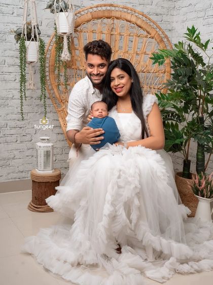 A picture-perfect family of three. This portrait captures the joy and love of the new parents as they hold their precious newborn baby.