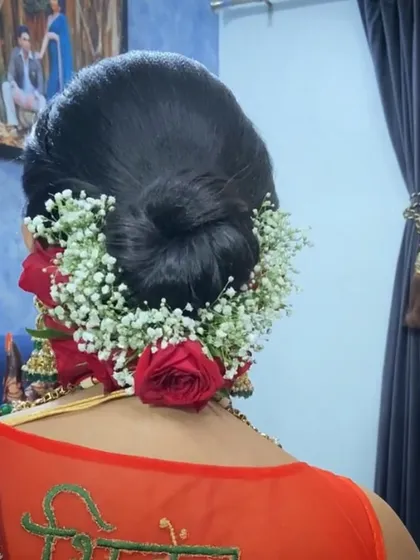 A traditional bridal bun completely covered in gajra and accented with red roses. A classic look for a Maharashtrian or South Indian bride.