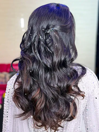 The hairstyle featured soft waves with a half-updo, sprinkled with glitter to match the "ice princess" theme of her outfit.